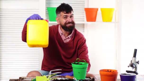 Agricultor barbudo con bidón de plástico amarillo que contiene pesticidas para el procesamiento de plantas en la agricultura. Fertilizante para plantas agrícolas. El hombre planta y fertilizar las plantas. El hombre ofrece bote . — Vídeos de Stock