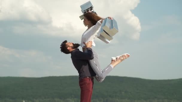 Happy young couple holding shopping bag. Concept of fun shopping. They love shopping together. Cheerful young loving couple stretching out shopping bags and smiling while walking along the street. — Stock Video