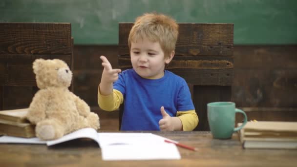 Menino contando com dedos com fundo de quadro verde. De volta à escola. Educação, infância e conceito escolar. O miúdo está a aprender a contar. Adicionando números com as mãos. Aula de matemática no jardim de infância . — Vídeo de Stock