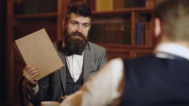 Akıllı elite ve eğitim kavramı. Arka plan üzerinde antika kitap rafı erkeklerle. Akıllı adamlar, bilim adamları kitaplığında boş zaman harcamak. Konuşan Profesör veya eğitim vintage iç tartışmak.