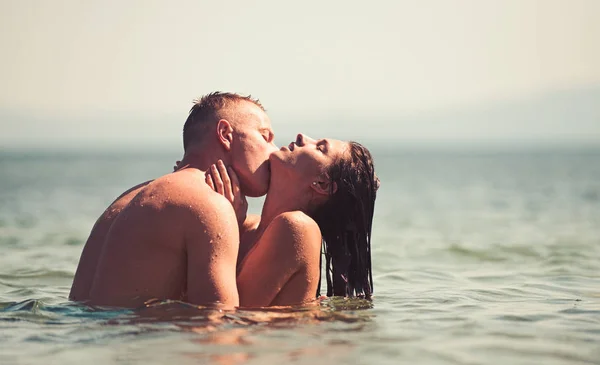 Glückliches Paar am Strand küsst sich im Wasser. — Stockfoto