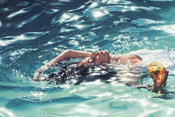 Πίνετε κοκτέιλ ενώ κολυμπάτε. γυναίκα πίνοντας κοκτέιλ στην πισίνα — Φωτογραφία Αρχείου