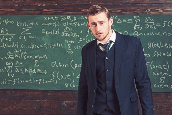 Intelligent man in suit standing in classroom. Aristocrats and elite concept