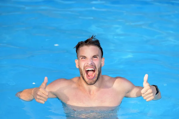 豪华游泳池 - 兴奋。性感的家伙在蓝色的水域在海滩上。蓝色海滩背景上强大的肌肉男性身材。运动型男子在蓝色水上穿泳装. — 图库照片