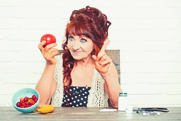 Sorriso de mulher sênior com maçã na mão — Fotografia de Stock