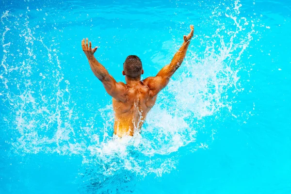 Mavi su arka plan üzerinde mükemmel erkek Gövde. Paradise'ta tatil. Tatil. Lüks Seyahat Uzmanı. Genç adam Yüzme Havuzu Konsepti. Bahamalar veya Bermuda rahat - seyahat kavramı.