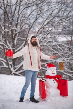 İndirim ve kış satış konsepti. Alışveriş çantası ile Komik kardan adam - indirim ve kış satış konsepti. Mutlu baba ile güneşli kış gününde mutlu gülümseyen kar adam.
