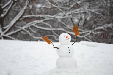 Kar taneleri ve kardan adamla kışın. Hediye kutularıyla kışın Noel manzarasında duran mutlu kardan adam. Mutlu Noeller ve fotokopi alanlı mutlu yıllar..