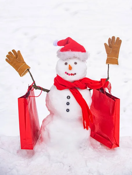 Bonito boneco de neve numa aldeia nevada. Saudação boneco de neve. Boneco de neve artesanal na neve ao ar livre. Boneco de neve cavalheiro em chapéu de inverno . — Fotografia de Stock