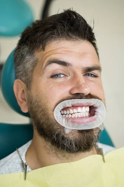 Homme mignon souriant regardant caméra. Portrait d'un homme joyeux avec des dents blanches comme neige. Homme âgé ayant un traitement dentaire au cabinet des dentistes. Professionnalisme service médecine santé concept . — Photo