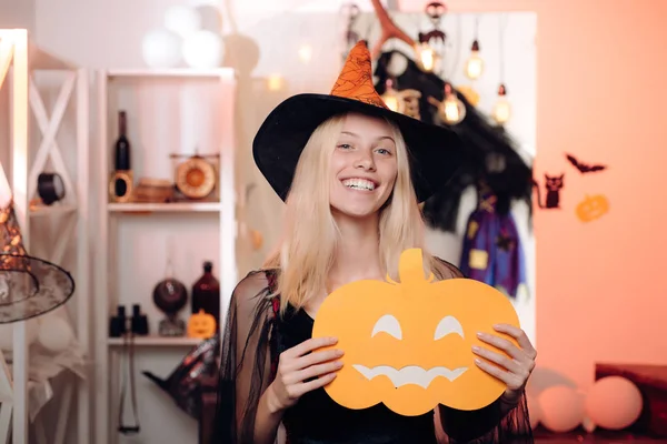 Sukienki na Halloween i stroje czarownic Design. Całkiem młoda blond kobieta ubrana jak Wróżka z dynią. Uroczy Halloweenowy czarownica z miotłową na tle rocznika. — Zdjęcie stockowe