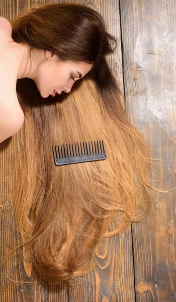 Pompás haj. Modell göndör frizura. Hair Salon koncepció. Ápolás és hajápolási termékek. Sampon és kondicionáló. Szakszerű ápolás. Lenyűgöző szépsége. Nő, hosszú hajú, fából készült háttér — Stock Fotó