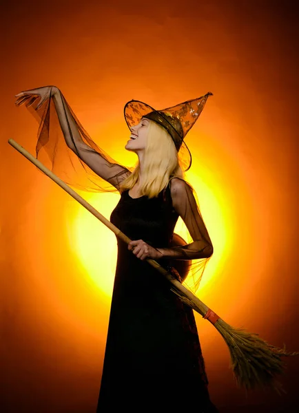 ヴィンテージの背景の上にほうきを持つ魅力的なハロウィーンの魔女。ヴァンパイアハロウィーンの女性の肖像画。黒い帽子のハロウィン魔女面白い表現。幸せな人たち楽しんで. — ストック写真