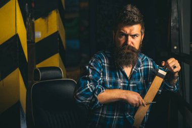 Berber dükkanında kuaförü ziyaret eden adam. Kırpar. Berber, berber dükkanında sakallı bir adamı tıraş ediyor. Tıraş örüntörüyle stil yapıyor. Berber makası. Tıraş adam ve jilet adam.