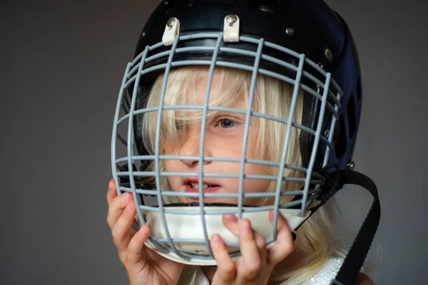 Sport neveltetés és karrier. Lány aranyos gyermek viselni Jégkorong sisak közelről. Biztonság és védelem. Védőháló az arcon. Sportfelszerelés. Jégkorong vagy rögbi sisak. A sport gyermekkori. Jövő sportsztár — Stock Fotó