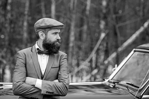 Call boy in vintage auto. Travel and business trip or hitch hiking. Escort man or security guard. Bearded man in car. Retro collection car and auto repair by mechanic driver