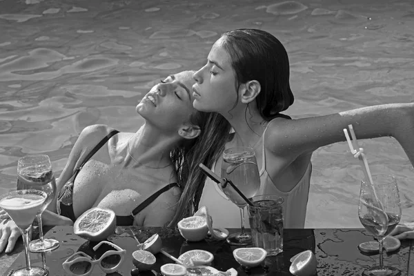 Κοκτέιλ στα κορίτσια στην πισίνα στις Μαλδίβες. Καλοκαιρινές διακοπές και κολύμπι στη θάλασσα. Γυναίκες της μόδας με ανανέωση αλκοόλ και φρούτων στο Μαϊάμι. Το πάρτι της πισίνας Χαλαρώστε στο θέρετρο σπα. φίλους και την ιδέα της φιλίας — Φωτογραφία Αρχείου
