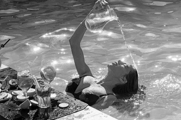 water drinking in summer pool. girl drink water from glass jar.