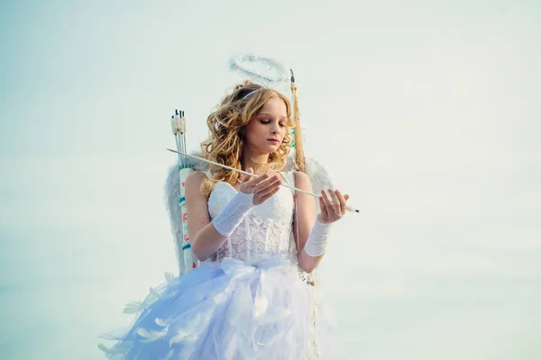 Niño con carácter angelical. Concepto de Valentín Daygirl vestido como un ángel sobre un fondo claro. Un niño con la ropa de un ángel en el fondo del cielo. Dulce niña ángel — Foto de Stock