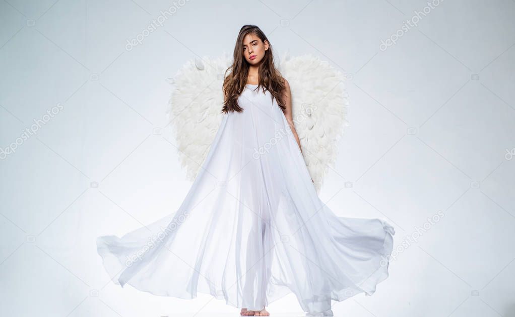 Romantic young beauty as an angel. Valentines Day symbol. Long white wings. Valentines day and costumes concept.