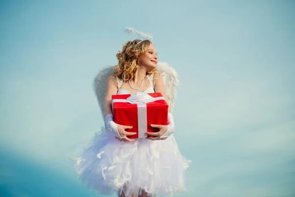 Αθώο κορίτσι με φτερά αγγέλου που στέκονται με τόξο και βέλη εναντίον του γαλάζιου ουρανού και των λευκών νεφών. Έφηβος άγγελος. Όμορφο λευκό κοριτσάκι ως ο έρωτας συγχαρητηρίων για την ημέρα του Αγίου Βαλεντίνου. — Φωτογραφία Αρχείου