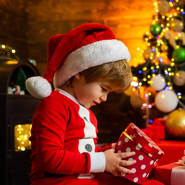 Это чудо. Семейный праздник. Мальчик милый ребенок веселый настроение играть возле рождественской елки. Счастливого и светлого Рождества. Маленький мальчик Санта празднует Рождество дома. Любимая детская забава — стоковое фото