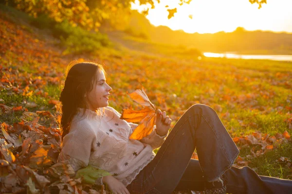 가을의 따뜻한 순간. 여자 예쁜 여자는 가을을 즐길 수 있습니다. 화창한 가을 날에 여자 편안한 누워 낙엽. 따뜻함과 아늑함. 여성 단풍 배경입니다. 저녁 태양광 선보 잡기 — 스톡 사진
