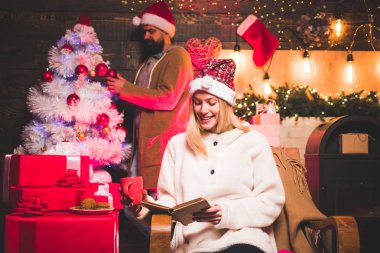 Yeni yıl moda konsepti. Kış trendleri ve sezon modası. Ev Noel atmosferinde şehvetli çift. Ahşap arka plan üzerinde Noel süslemeleri ve hediye kutusu.