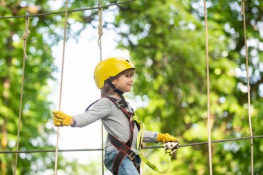 Çocuklar eğleniyor. Kask ve güvenlik ekipmanları. Kask ile Güvenli Tırmanma ekstrem spor. Küçük çocuk çocukluk yıllarını sever. Bir ağaç evde veya bir ip parkta güvenlik ekipmanları tırmanma Sevimli çocuk tırmanıyor
