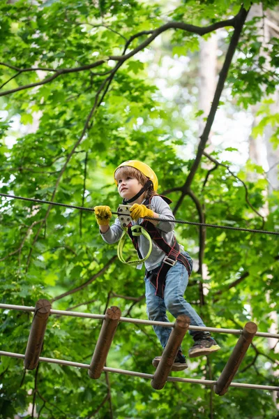 Go Ape Adventure. Climber child on training. Child climbing on high rope park. Children fun. Cargo net climbing and hanging log. Active children. Roping park — Stock Photo, Image