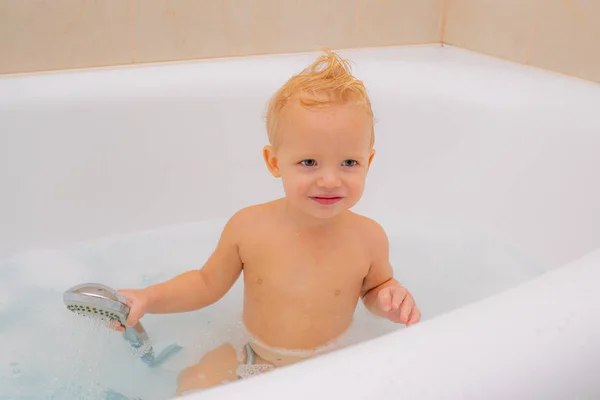 泡泡浴。小婴儿洗泡泡。浴室。小孩子洗澡泡沫，洗自己的头和微笑. — 图库照片