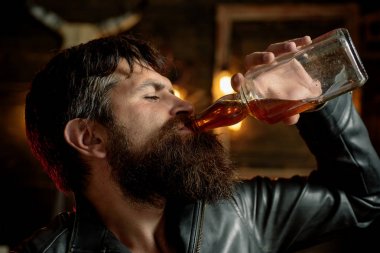 İçki içen adam telefonunu çatlıyor. Elinde bir bardak viski tutan adam. Viskiyi yudumlarken. Degustation, tatma. Berber. Tıraş. Sakallı yakışıklı bir adamın portresi.