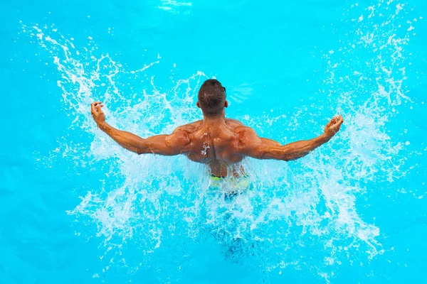 파란색 해변에서 건장 한 남성의 모습을 하고 있습니다. 아름다운 젊은이가 해변에서 쉬고 있습니다. 젊은 남자 수영 수영장 컨셉. 건강 한 몸. — 스톡 사진
