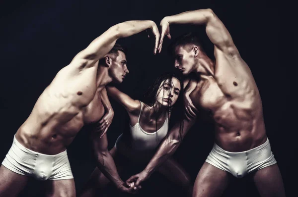 Scuola di ginnastica ed energia. Ginnasti di circo a pilates o formazione di yoga. forma del corpo del cuore delle persone sportive. Fitness e dieta. concetto di San Valentino. Gemelli uomini con corpo muscoloso e ragazza — Foto Stock