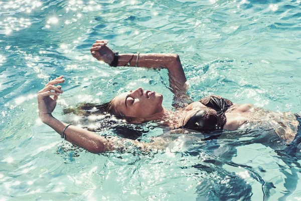 Femme sexy sur la mer des Caraïbes aux Bahamas. Détendez-vous dans la piscine spa, le rafraîchissement et les soins de la peau. Maldives ou Miami plage d'eau. Beauté de la femme est hydratée. Vacances d'été et voyage à l'océan . — Photo