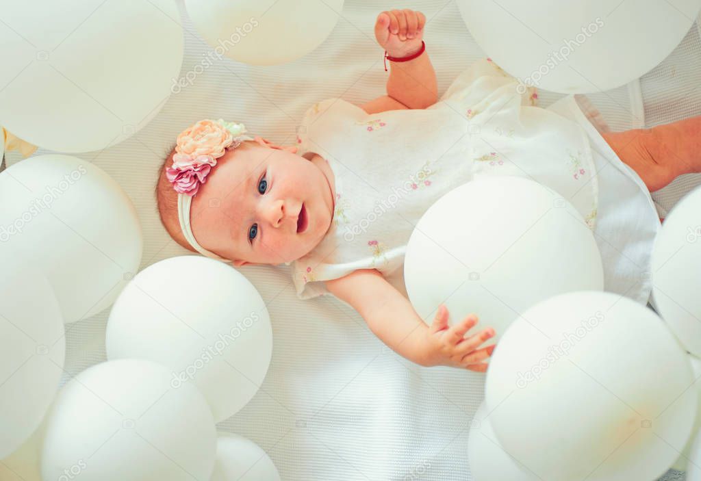 Cute little baby. Family. Child care. Childrens day. Sweet little baby. New life and birth. Portrait of happy little child in white balloons. Small girl. Happy birthday. Childhood happiness