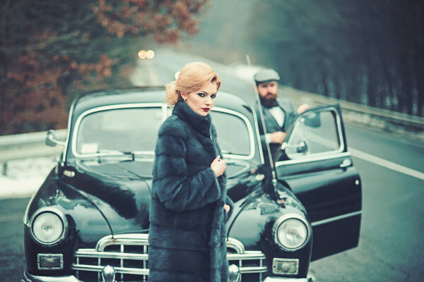 hitch hiking on road with luxury people. hitch hiking of retro car by woman and bearded man.