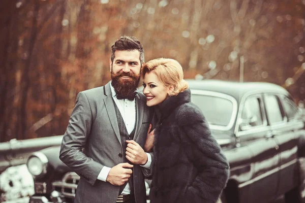 Wealthy couple at a classic retro car.