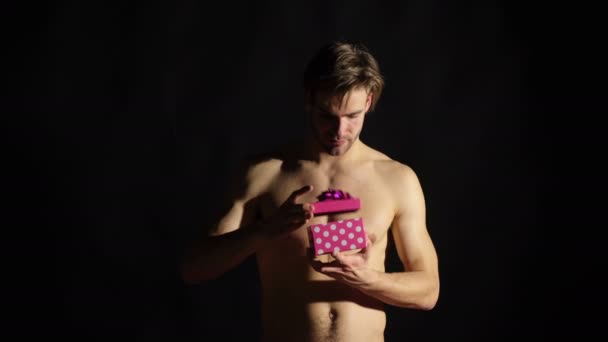 Hombre sexy con una caja de regalo aislada sobre fondo negro. Macho torso hombre mantenga y abra la caja de regalo. Un regalo para ti. Concepto de San Valentín. Hombre atractivo con caja rosa. Hombre con regalo romántico . — Vídeo de stock