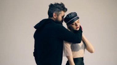 Beyaz arka planda genç bir çift. Bisiklet severler. Hippiler bayılır. Rock tarzı. Klasik kafe yarışçısı. Yakışıklı sakallı adam ve genç çekici kadın birbirlerine sarılıp dokunuyorlar..