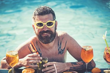 Miami beach veya Maldivler tatil yaz. Havuz partisi, vitamin ve diyet. Adam yüzme ve içecek alkol. Havuzda sakallı adam meyve kokteyli. Deniz ve spa resort sakin ol.