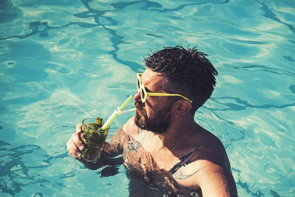 Havuz partisi hipster mavi su ile. Kokteyl parti havuzu sakallı adam. Adam yüzme ve içecek alkollü mojito. Deniz ve spa resort sakin ol. Miami beach veya Maldivler tatil yaz