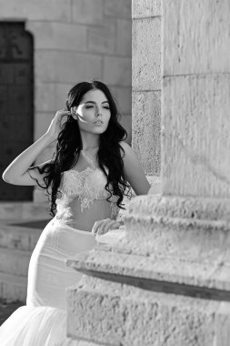 Kadın taş antik sütun yazın. Şık saç ile beyaz elbiseli seksi kız. Şatodaki düğün töreninde gelin kız. Düğün moda ve güzellik salonu. Moda modeli ya da Prenses Giydir.