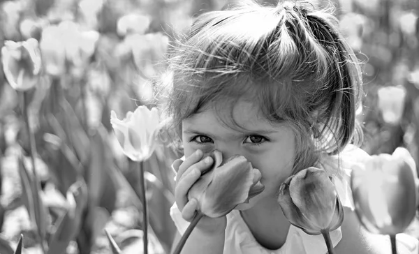 Niebezpieczeństwo w wazonie. Pielęgnacja skóry twarzy. Alergia na kwiaty. Małe dziecko. Naturalne piękno. Dzieci dzień. Dziewczynka w słoneczny wiosenny. Moda dziewczyna lato. Szczęśliwe dzieciństwo. Tulipany wiosna. Prognoza pogody — Zdjęcie stockowe