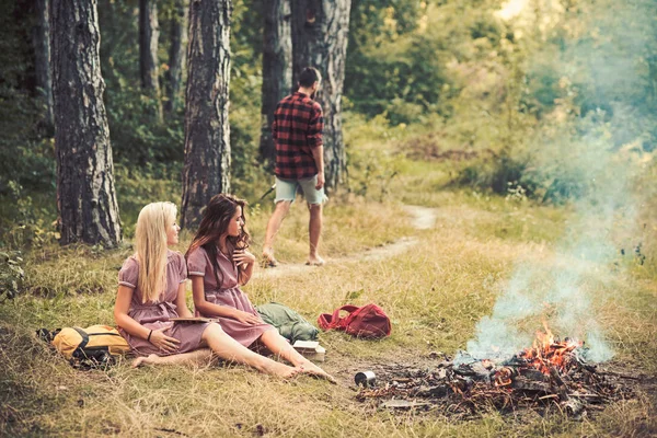 Giovani ragazze che leggono libri nella foresta o nel parco. Belle donne sedute vicino al falò. Ragazzo che cammina sul sentiero nel bosco — Foto Stock