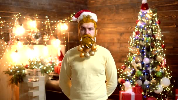 Babbo Natale - hipster barbuto. Vestiti di moda di anno nuovo. Uomo Capodanno. Un pazzo barbuto che guarda la telecamera. Babbo Natale in casa. Bell'uomo barbuto elegante. Fai una faccia buffa . — Video Stock