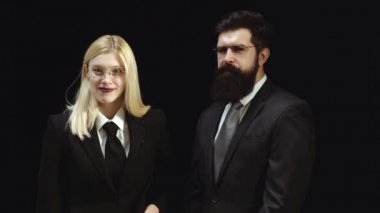 Öğretmen adam ile seksi muhteşem sarışın kadın. İşadamı izole - yakışıklı adam ve siyah arka plan üzerinde duran güzel bir kadın. İş çifti birlikte çalışıyor.