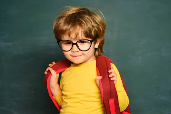 Skolbarn. Kid lär sig i klass på bakgrund av Blackboard. Inlärnings koncept. Söt liten förskola Kid Boy i ett klassrum. — Stockfoto