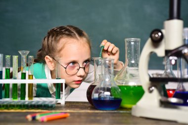 Okula ve evde eğitim görmeye. Bilim ve eğitim konsepti. Küçük mutlu bilim adamı deney tüpüyle deney yapıyor. Portreleri kapatın..