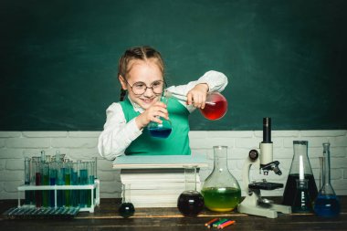 Kimya üzerine yeni bir deney yaptılar. Küçük mutlu bilim adamı deney tüpüyle deney yapıyor. Okula dönelim. Okula ve evde eğitim görmeye..